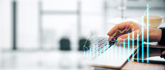 Closeup of a man analyzing financial data on a laptop with graphs on screen, modern office background.