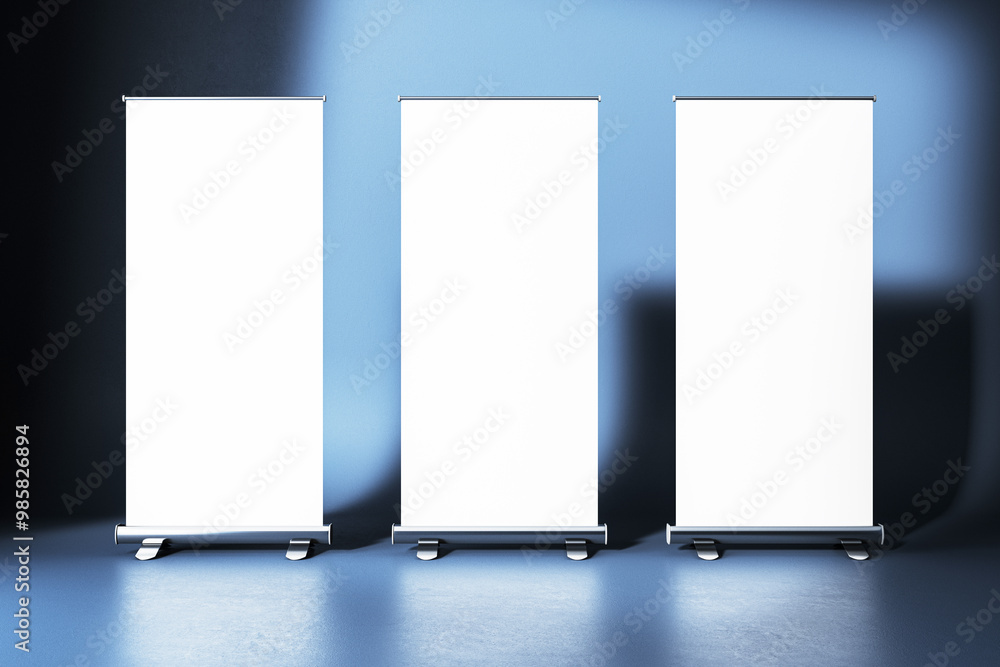 Aufkleber mockup of three roll-up banners in a studio with blue gradient background. 3d rendering