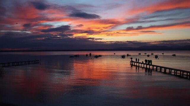 People enjoying lakeview at sunset from footbridge at Pacengo, Lazise, Lake Garda, Italy