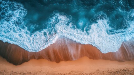 An aerial view of ocean waves forming patterns in the surf as they approach a sandy beach.