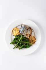 Savor the wholesome flavors of baked green beans with onions and baked mackerel, elegantly plated...