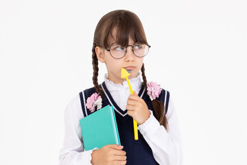 Thoughtful deciding schoolgirl in glasses with backpack, pen and notepad, preteen kid thinking looking at copy space having question. Kid student standing isolated on white background