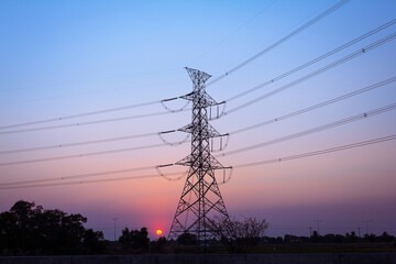 Hi-voltage electrical pole with sunset background.