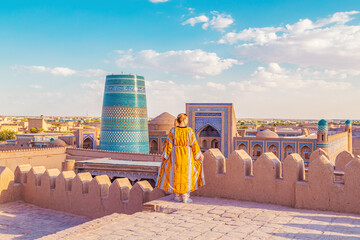 Woman in a traditional robe admires the town of Ichan-Kala.
