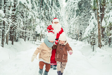 Santa Claus with a bag of gifts and children in a snowy forest.