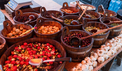 Delicious Mediterranean food display at Notting Hill Market, London – Fresh olives, marinated vegetables, and garlic in rustic wooden bowls for culinary and cultural themes