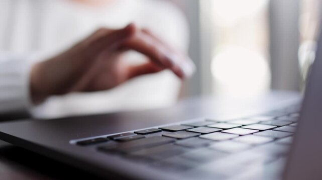 Close-up of hands of unrecognizable businesswoman typing on laptop keyboard while working online. The concept of remote work online, freelancing and successful business.