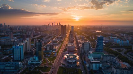 Naklejka premium Aerial view of a city at sunset with buildings and streets lit up by the golden hour