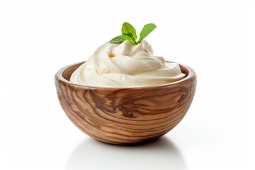 Fresh whipped cream and a sprig of mint in a rustic wooden bowl, perfect for desserts or special occasions