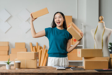 Small Business Success: A young, energetic woman entrepreneur celebrates a milestone in her...