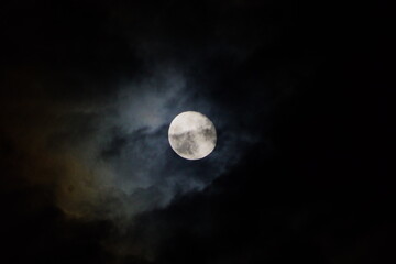A moon in the dark cloudy cold night.