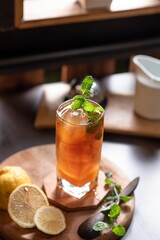 cup of tea, This photo features a glass of cold beverage, possibly lemon iced tea, served in a tall glass with ice cubes and fresh mint leaves as garnish.