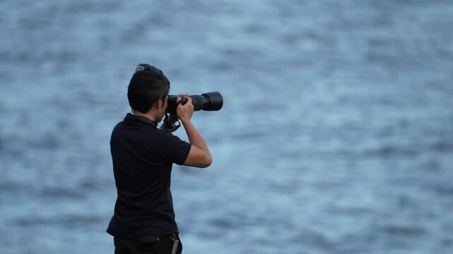 Man looking through a camera viewfinder to take a photo