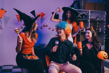 Joyful office Halloween party with coworkers in costumes, celebrating with drinks and laughter, fostering teamwork and festive spirit