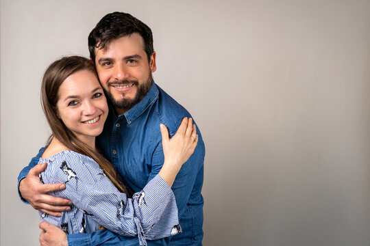 Pareja de enamorados tiernamente abrazados en un fondo claro con copy space