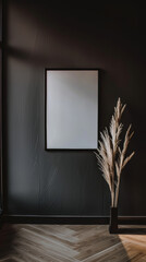 A minimalist interior featuring simple frame on dark wall, complemented by elegant dried plants in vase, creating serene and stylish atmosphere