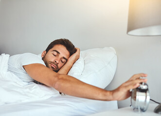 Wake up, alarm clock and man in bed with morning, sleeping and resting after pressing snooze...