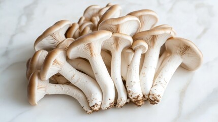 A close-up of a cluster of oyster mushrooms on a white marble surface.