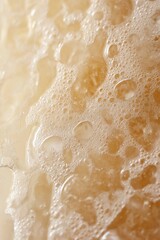 Fototapeta premium A detailed close-up view of frothy beer foam with tiny bubbles, highlighting the texture and freshness of the beverage.