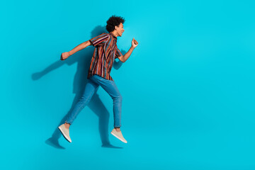 Full body portrait of nice young man jump run empty space wear shirt isolated on turquoise color background