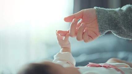 Close-up little hand of child baby holding hand of mother, A newborn holds on to mom's, dad's finger, Love and relationship with infant, Care and support, Dreaming and protection