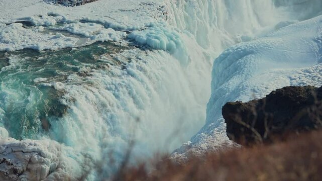 Gullfoss waterfall in Iceland, Cinematic beautiful majestic winter waterfall cover by snow and ice. Slow motion.
