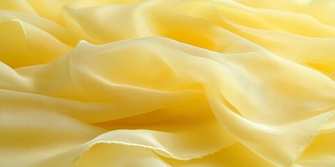 Obraz premium Delicate folds of pale yellow chiffon fabric, creating a smooth and elegant backdrop for design inspiration