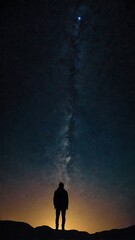 Fototapeta premium A starry night sky with a silhouette of a person gazin