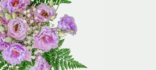 Bouquet Of Violet Lisianthus Flowers And Green Leaves Is Lying On The Left Side Of A White Background