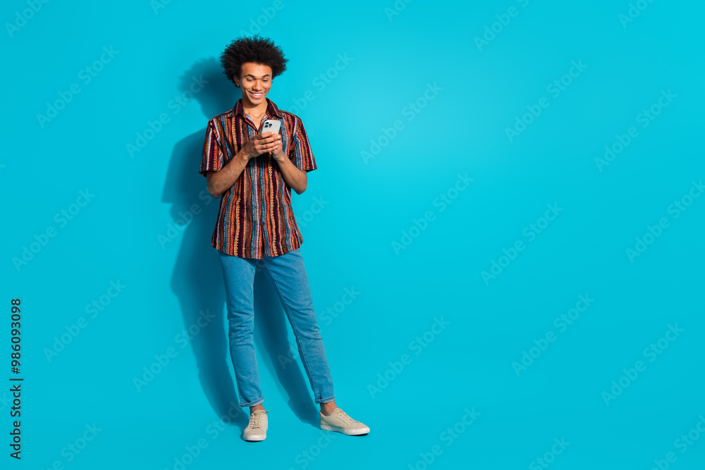 Wall mural full body portrait of nice young man smart phone empty space wear shirt isolated on turquoise color 