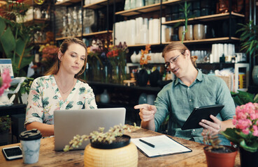 Small business, people and laptop at plants for brainstorming, budget review and teamwork in boutique. Man, woman and technology at table for marketing strategy, information and customer feedback