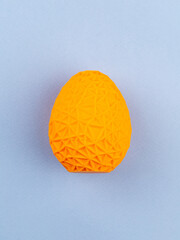 close-up volumetric colored egg with ornament on blue background
