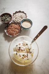 Seed cycling for hormonal balance - flax, pumpkin, sunflower and sesame seeds for different phases of menstrual cycle, women's health - a bowl of yogurt sprinkled with healthy seeds