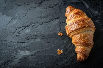 Fresh croissant on a black slate background. Top view . Copy space