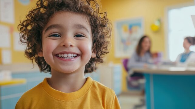 A child smiling as they receive care in a bright pediatric office filled with friendly faces and playful decor