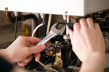 A man is repairing a water-heating boiler.