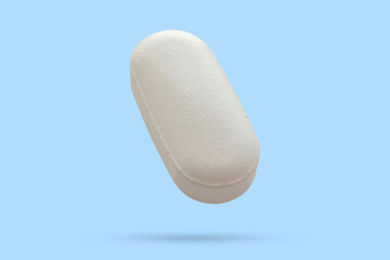 White medicine pill tablet float on blue background