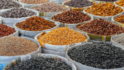 Bags of seeds and nuts on the market. Corn in tee focus