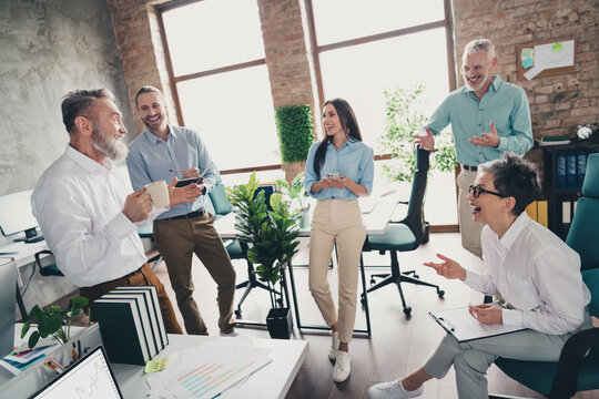 Full body photo of teamwork people working together talking communication comfortable modern office loft room interior indoors workspace