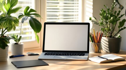 Laptop on wooden desk with open notebook, pen, and plants in pots near window.