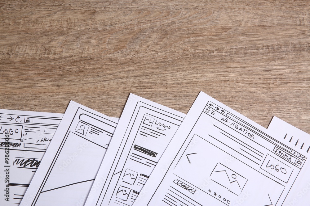 Poster developing ui design. sketches of website wireframes on wooden table, top view