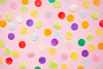 Flat lay of multicolored confetti on pink background