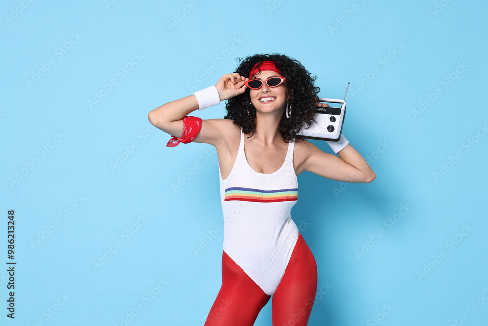 Wall mural Aerobics. Happy woman with radio receiver on light blue background