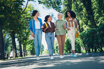 Full body portrait of group friends women speak chatting pastime weekend walk city center park...