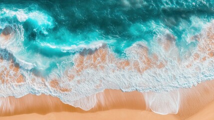 Obraz premium Aerial view of the ocean waves crashing on the sandy beach.