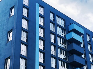 Real Estate concept. Minimal Architecture Background. Detail New blue high-rise Building or House Modern facade with windows. Contemporary geometrical architectural design backdrop. 
