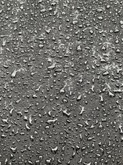 Water drops on black surface. Water droplets on dark background. Water droplets concept. Water drops on a black background. Banner with raindrops. Top view.