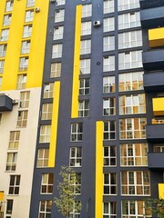 Architecture Background. Detail New high-rise Building or House Modern facade with windows. Contemporary geometrical architectural design backdrop. Real Estate concept. Yellow and Gray-Dark blue color