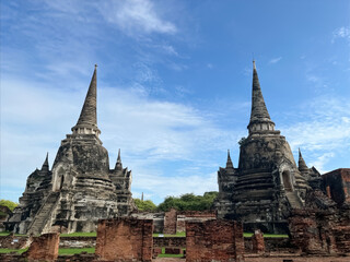 Fototapeta premium Ancient stupas of Wat Phra Si Sanphet in Ayutthaya Historical Park, Thailand. A UNESCO World Heritage Site showcasing classic Siamese architecture and rich cultural heritage under a clear blue sky