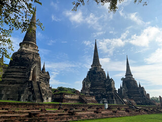 Fototapeta premium Ancient stupas of Wat Phra Si Sanphet in Ayutthaya Historical Park, Thailand. A UNESCO World Heritage Site showcasing classic Siamese architecture and rich cultural heritage under a clear blue sky